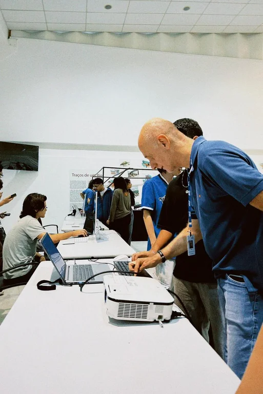 Visitantes testando o jogo nas mesas da exposição.