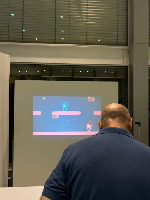 Visitante diante da projeção de uma fase do jogo.